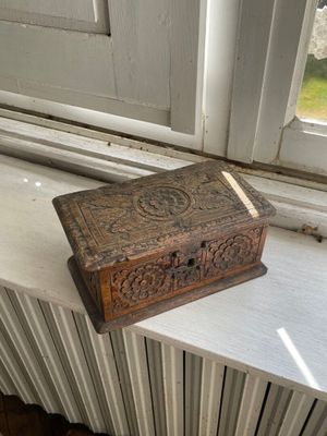une petite boîte en bois posée sur le rebord d'une fenêtre