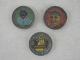 trois boutons de couleurs différentes sur lesquels figurent l'image d'un homme et d'une femme