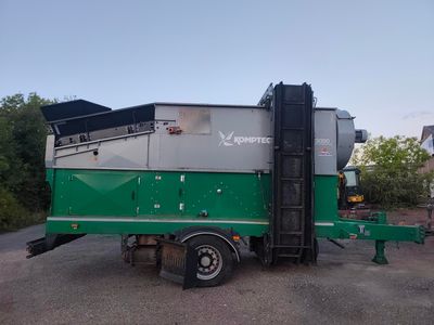 une photo d'une caravane verte et blanche garée sur un parking