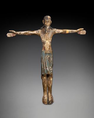 une statue en bronze représentant un homme les bras écartés