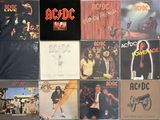 a lot of ac / dc album covers on the wall