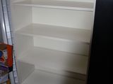une bibliothèque blanche dans un coin de la pièce