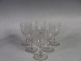 several empty wine glasses are lined up on a white surface