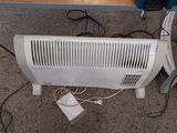 un radiateur blanc posé par terre à côté d'une table