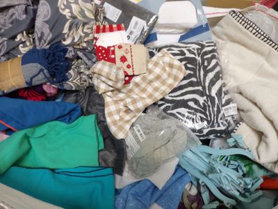 une valise pleine de vêtements posée par terre