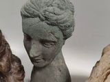 three clay sculptures of a woman ' s head and a man ' s head