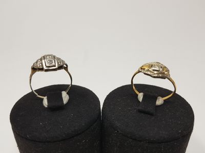 two gold and silver rings sitting on top of a black box