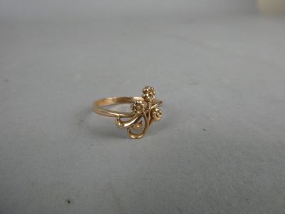 gros plan d'une bague en or sur une surface blanche