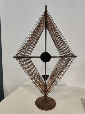 une photo d'une sculpture en fil de fer posée sur une table