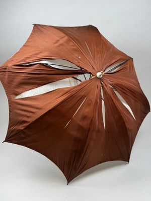 un parapluie marron ouvert sur fond blanc