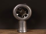 a metal fan that is sitting on a wooden table