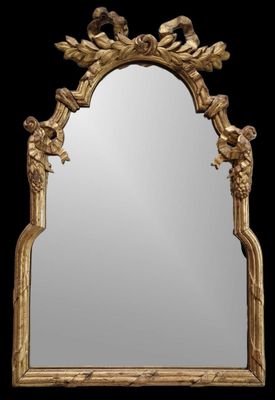 un miroir orné d'un cadre doré sur lequel sont représentés des oiseaux