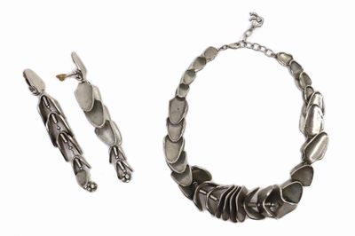 une photo d'un ensemble composé d'un collier et d'un bracelet en argent sur fond blanc