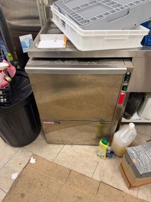 un lave-vaisselle posé par terre à côté d'une poubelle