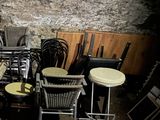 many chairs and tables in a room with a stone wall