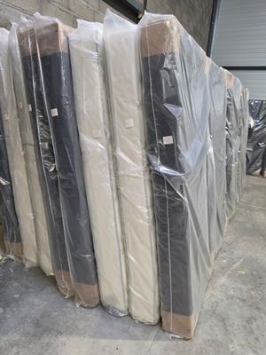 many mattresses wrapped up in plastic in a warehouse