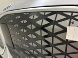 a sticker on the grill of a car that has a price tag attached to it