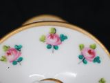 a close up of a white plate with pink roses on it