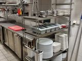 many plates and pans on the shelves in the kitchen