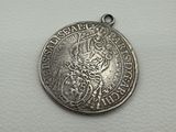 a silver coin with a lion on it sitting on top of a white surface