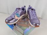 des baskets Puma violettes dans une boîte, sur fond blanc