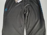 un gros plan sur un pantalon noir orné d'un logo bleu sur le côté