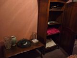 a small bed in a small room with a wooden armoire