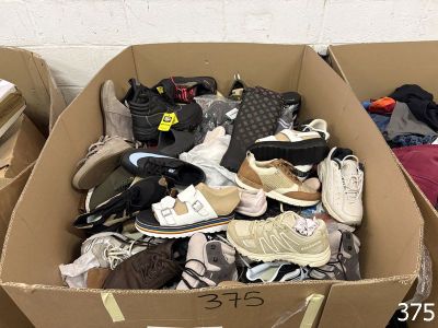 many pairs of shoes in a cardboard box on the floor