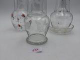three glass vases and a glass salt shaker on a white surface