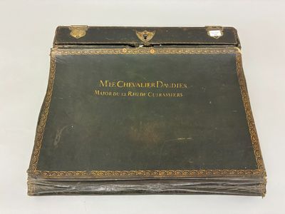 un livre vert orné d'inscriptions dorées, posé sur une surface blanche