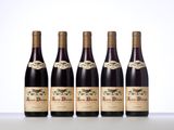 four bottles of wine are lined up on a table