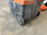 an orange and black machine that is sitting on the floor