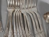 a lot of silver forks and spoons on the table