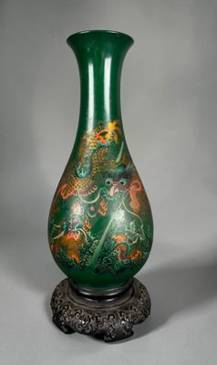 un vase vert posé sur un socle, sur une surface grise