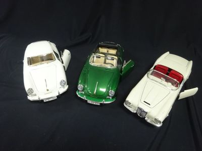 three toy cars sitting next to each other on a black surface