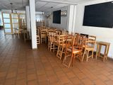tables and chairs in a room with a blackboard on the wall