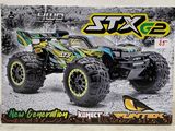 une boîte contenant un monster truck miniature, posée sur une table