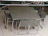 une table et des chaises qui se trouvent dehors, sur la terrasse