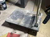 a metal object on the floor next to a paint can
