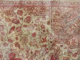 an old carpet with a red and beige design on it