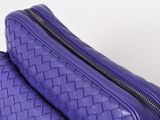 a close up of a purple bag on a white surface