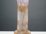 un vase en verre posé sur une table, sur fond gris