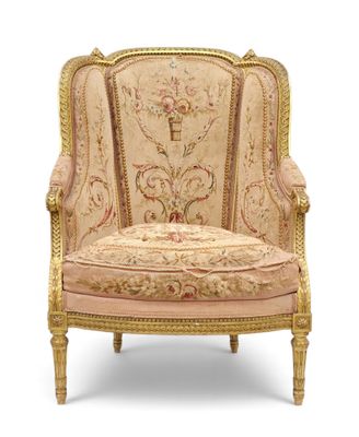 FAUTEUIL A OREILLE En bois doré et sculpté, ganri d'une tapi…