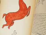 an open book with a picture of a red horse on it