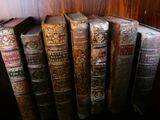 Plusieurs vieux livres sont alignés sur une étagère près d'un radiateur