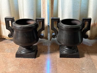 deux urnes noires posées l'une à côté de l'autre sur un sol carrelé