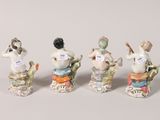 four figurines of cats sitting in a row on top of each other