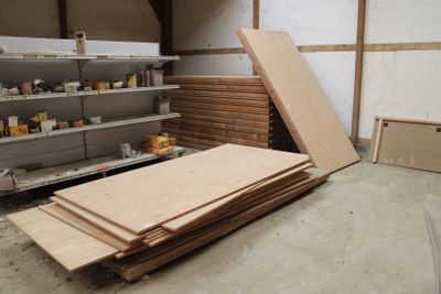 un tas de bois non scié dans une pièce équipée d'étagères