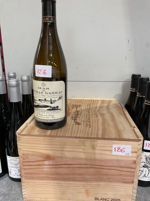 une caisse en bois sur laquelle est posée une bouteille de vin