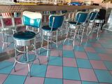 beaucoup de tabourets alignés devant un bar